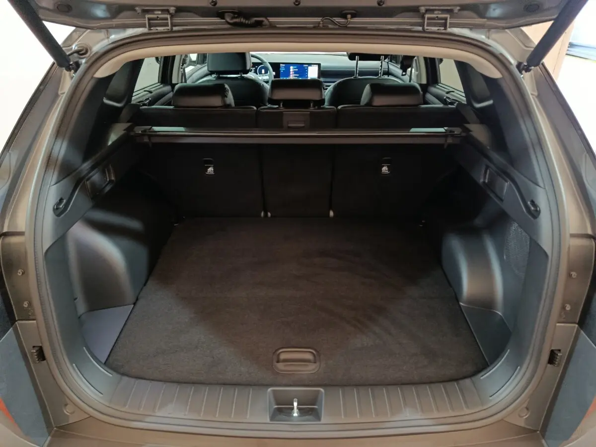 Coffre ouvert d’un Hyundai Tucson gris foncé, vue arrière montrant l’espace de chargement et l’intérieur noir.