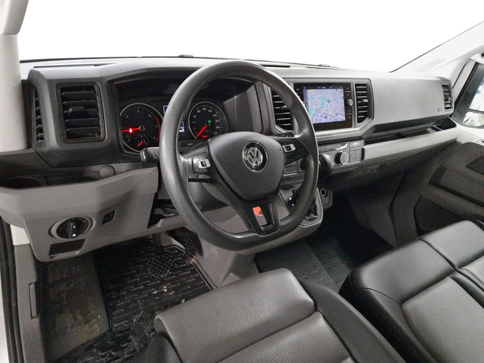 Vue intérieure du poste de conduite du Volkswagen Crafter blanc, avec volant multifonction et écran tactile central.