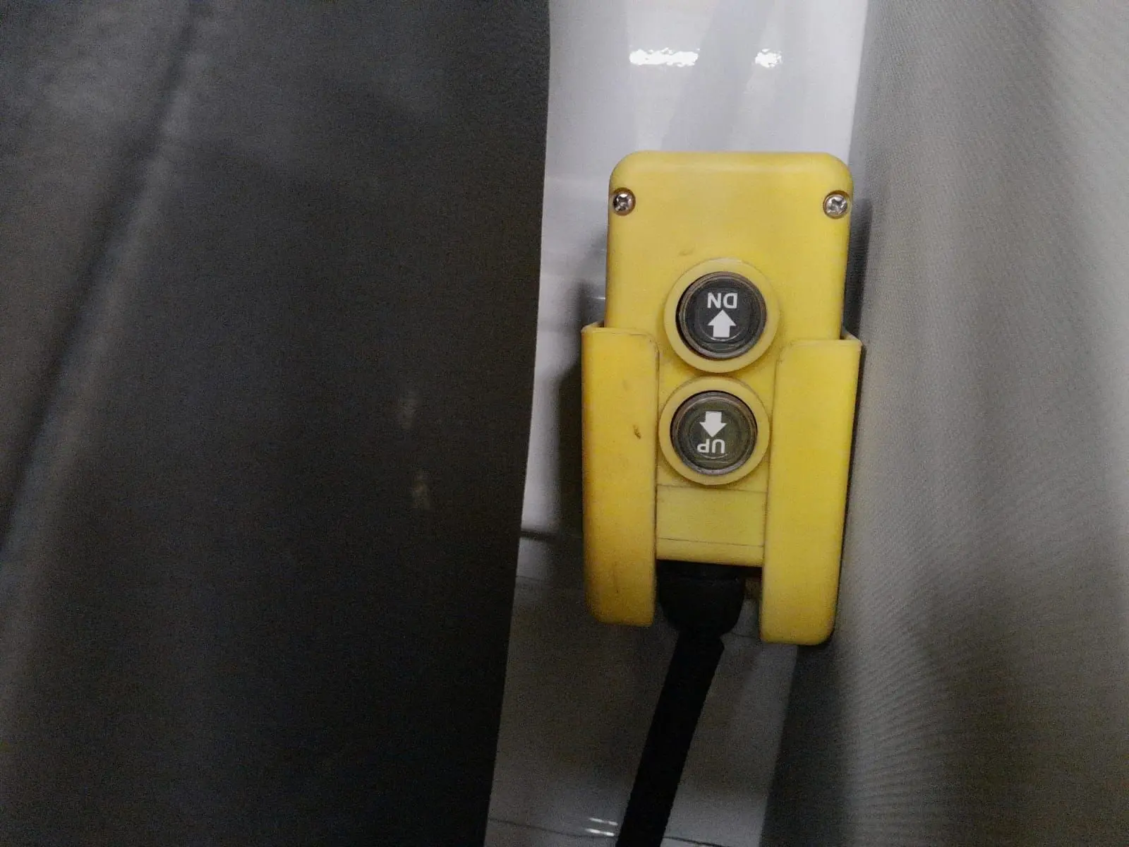 Gros plan sur la commande jaune de levage avec boutons up et down à l'intérieur d'un Volkswagen Crafter blanc.