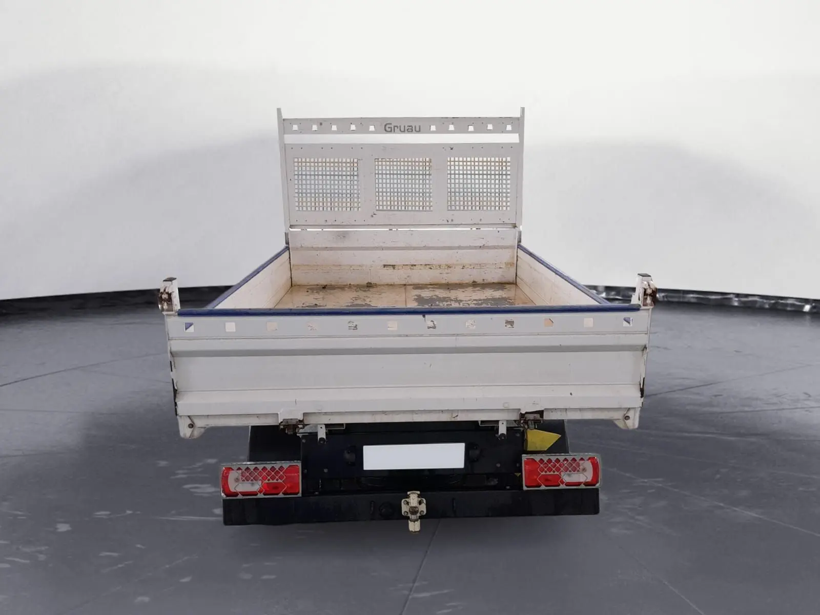 Vue arrière d'un Volkswagen Crafter blanc avec benne et coffre, équipé de roues jumelées et attelage visible.