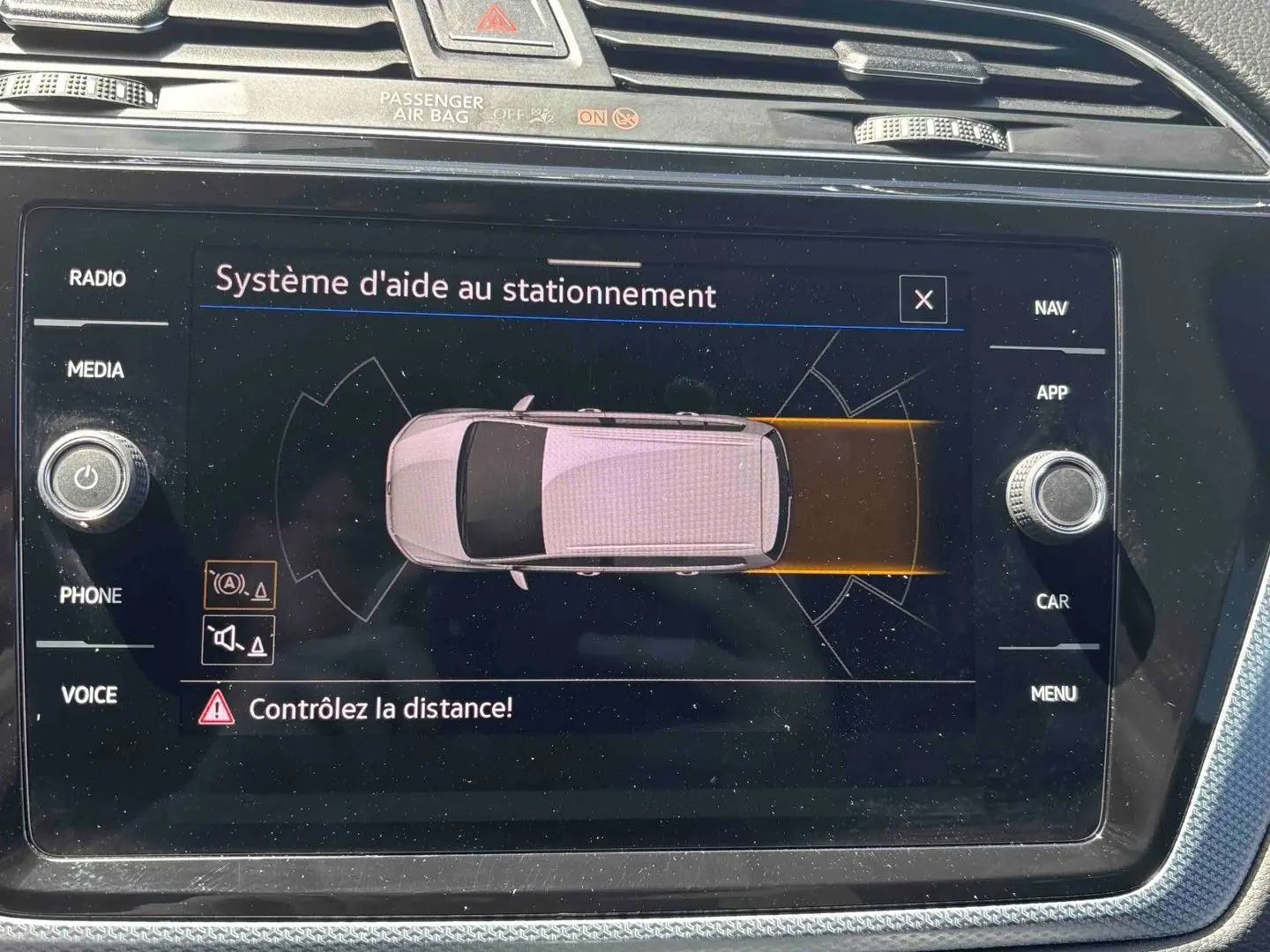 Écran tactile du système d'aide au stationnement du Volkswagen Touran 2025 affichant une vue top-down du véhicule.