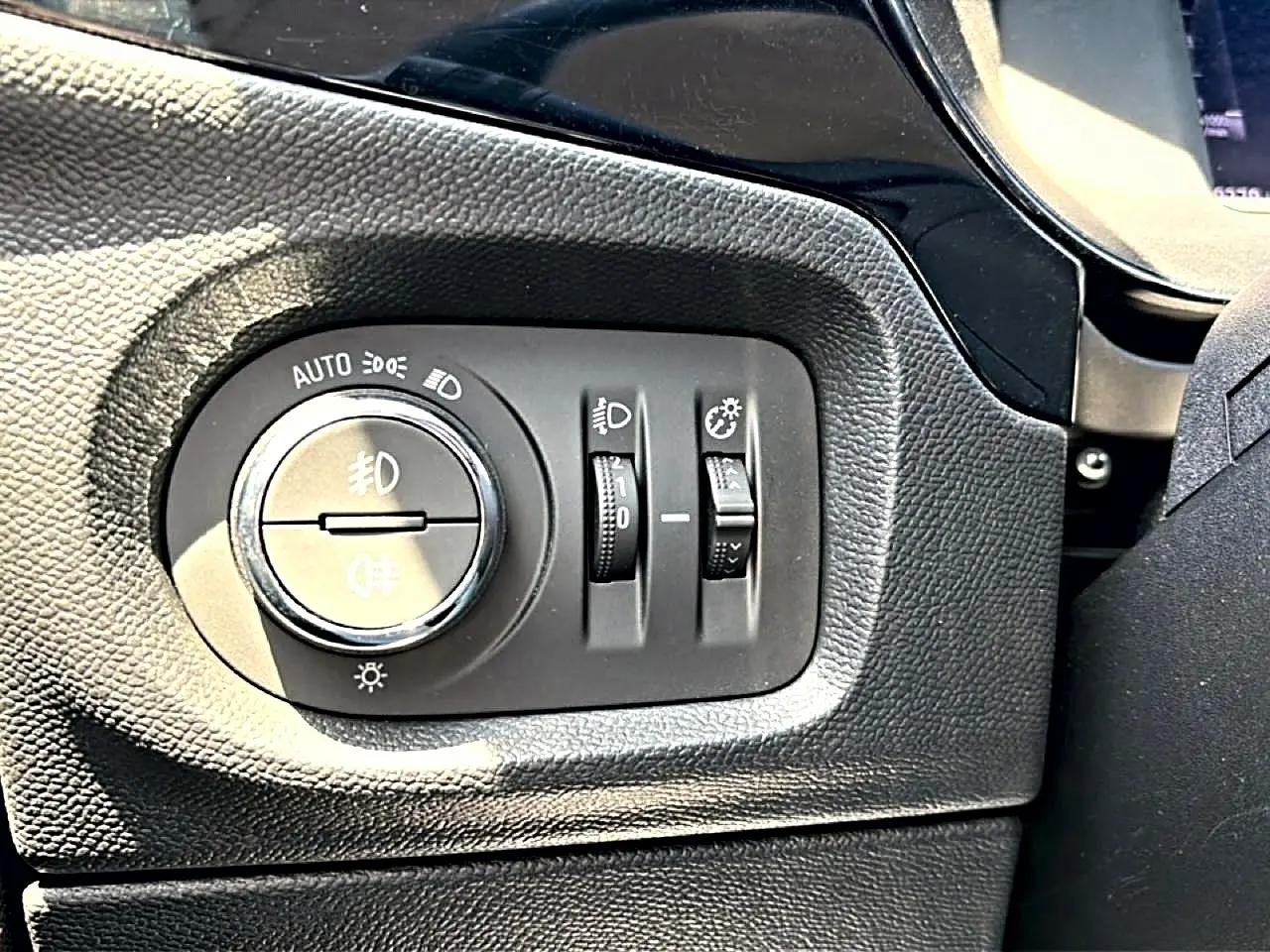 Gros plan sur les commandes d’éclairage intérieures en plastique noir de l’Opel Corsa 2025.