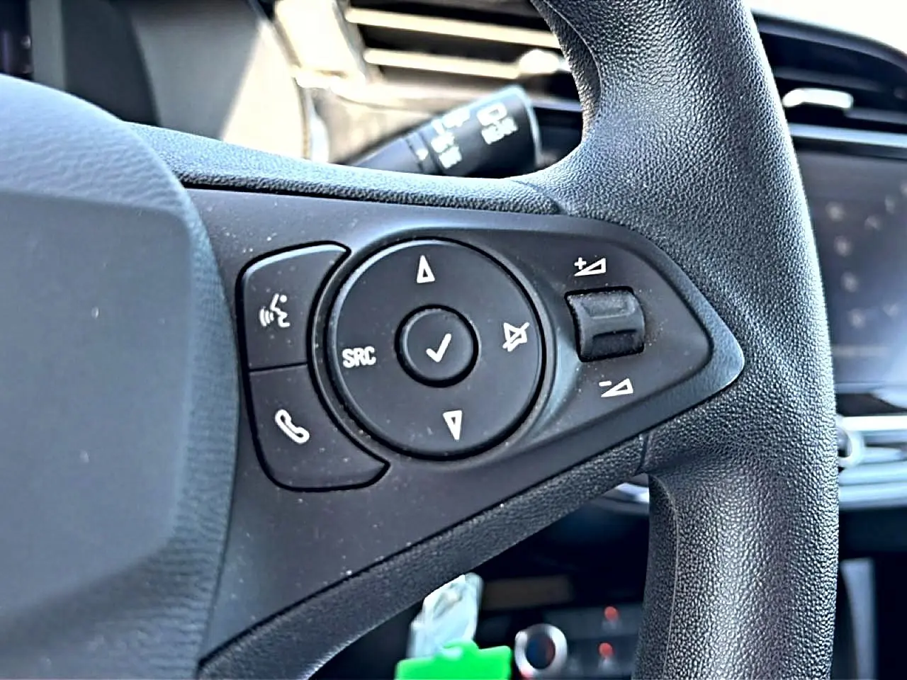 Gros plan sur les commandes du volant noir de l’Opel Corsa 1.2 Turbo 100 Edition, intérieur moderne et fonctionnel.