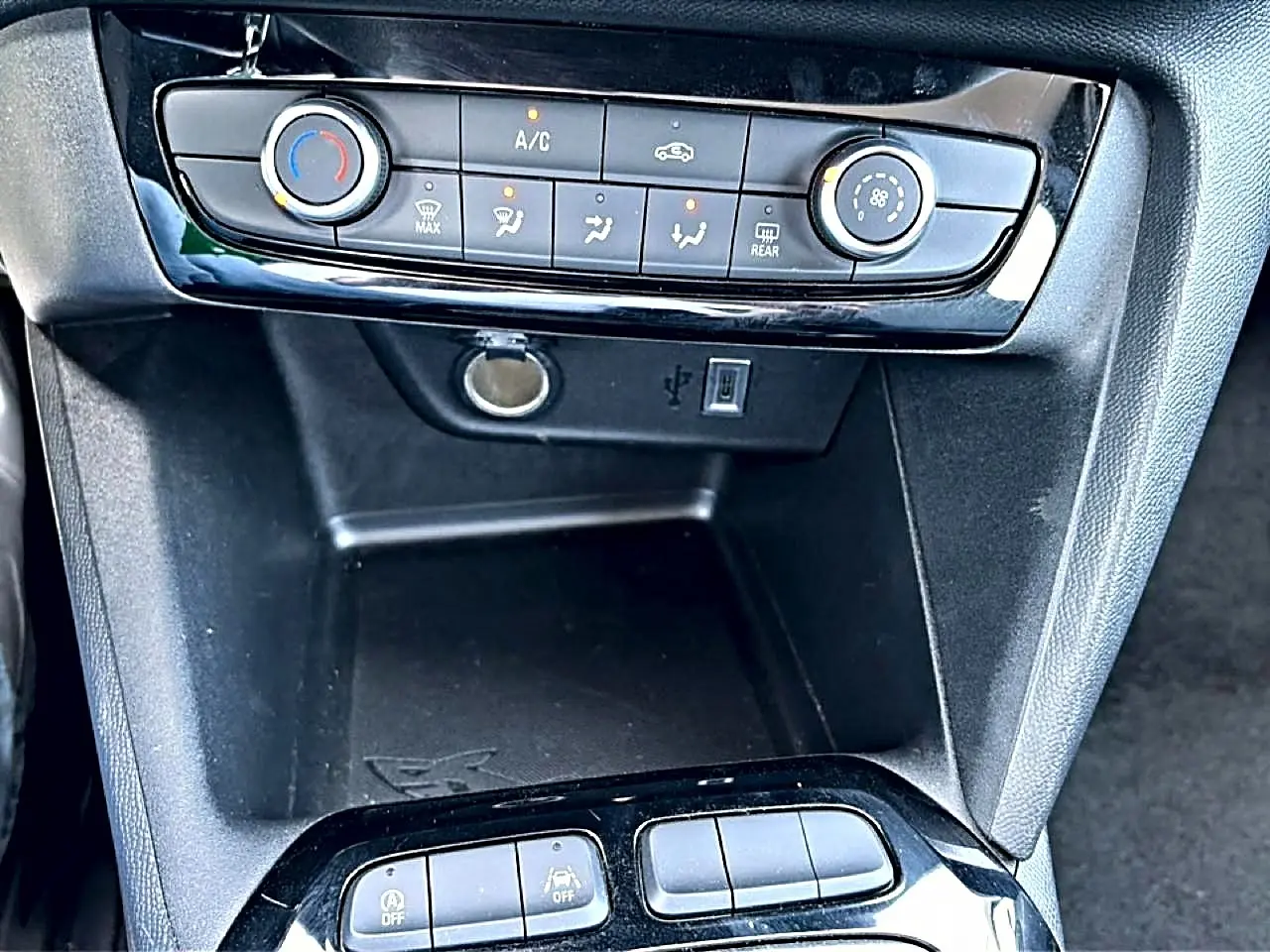 Détail du tableau de bord noir de l’Opel Corsa 1.2 turbo 100 édition avec commandes clim et prise USB visible.