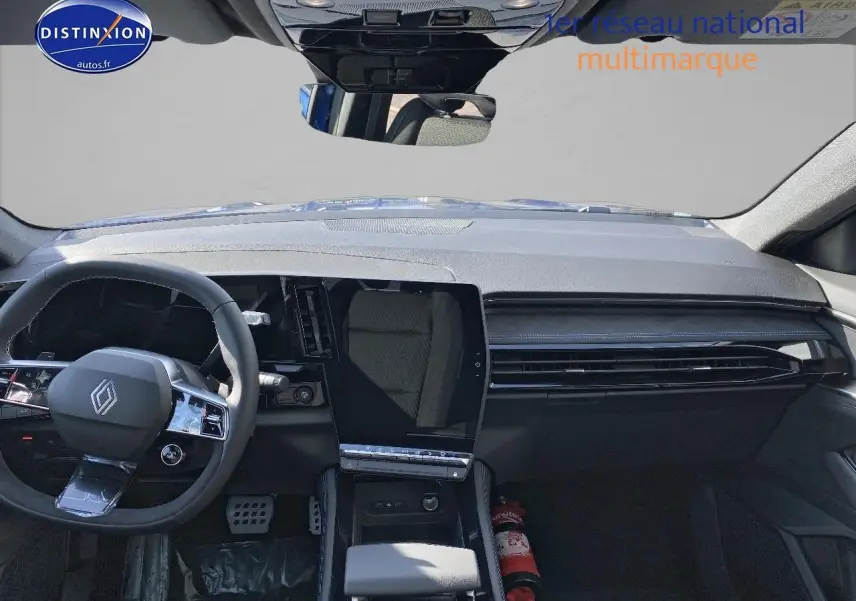 Vue intérieure avant du Renault Austral 2025 bleu iron, tableau de bord moderne avec écran tactile vertical et volant multifonction.