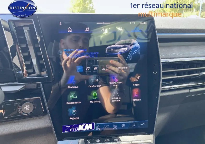 Écran tactile central affichant les options de conduite du Renault Austral bleu iron, intérieur moderne avec détails noirs.