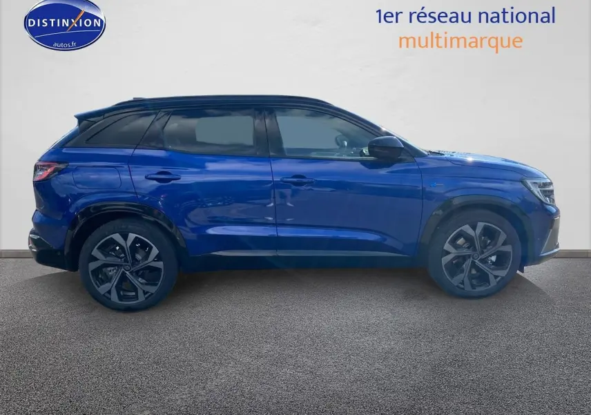 Profil côté gauche du Renault Austral hybride 2025 en bleu iron avec toit noir et jantes alu distinctives.