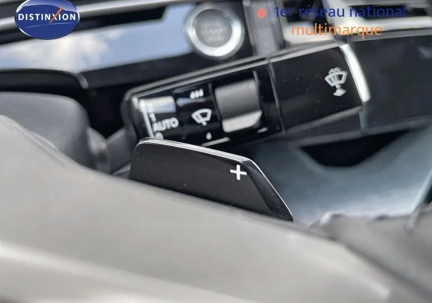 Gros plan sur la palette de changement de vitesse "+" côté droit du volant d'un Peugeot 3008 Hybrid 2025.