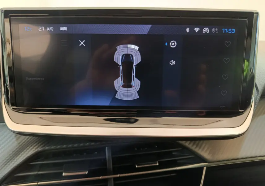 Écran tactile central affichant la vue aérienne du système d'aide au stationnement dans une Peugeot 208 gris clair.