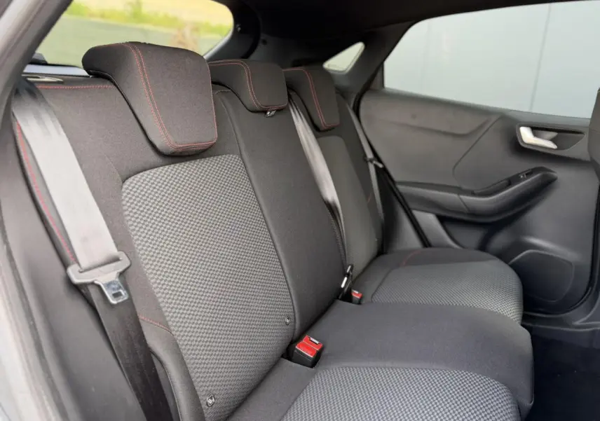Vue intérieure côté droit des sièges arrière noirs avec surpiqûres rouges du Ford Puma Ecoboost 155 BVA ST Line 2024.