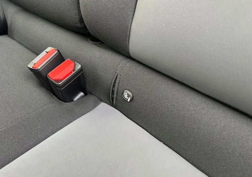 Gros plan sur la banquette arrière noire avec fixation Isofix et boucles de ceinture rouges du Dacia Sandero III Stepway.