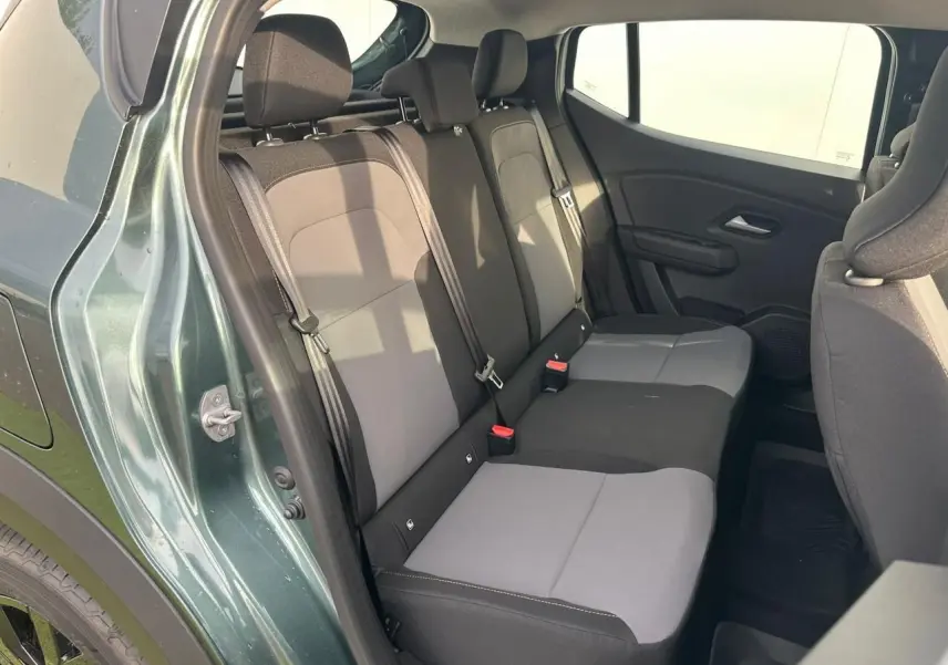 Vue intérieure côté gauche sur la banquette arrière grise et noire du Dacia Sandero III Stepway Vert Cèdre 2025.