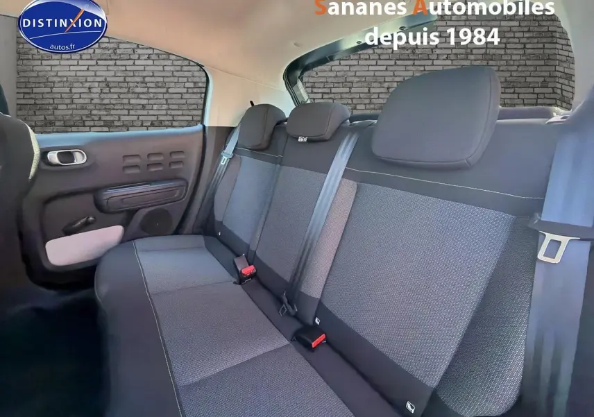 Vue intérieure arrière sur les sièges tissu gris et noir de la Citroën C3 1.2 PureTech 2022, côté gauche visible.