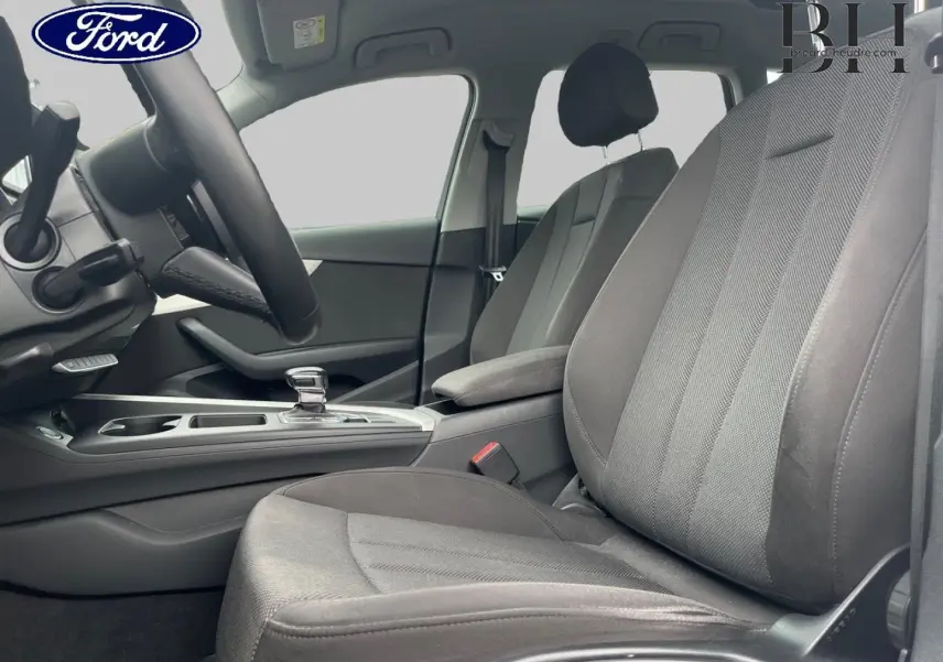 Vue intérieure côté conducteur de l'Audi A4 Avant 30 TDI 2021, sièges tissu gris et console centrale avec levier automatique.