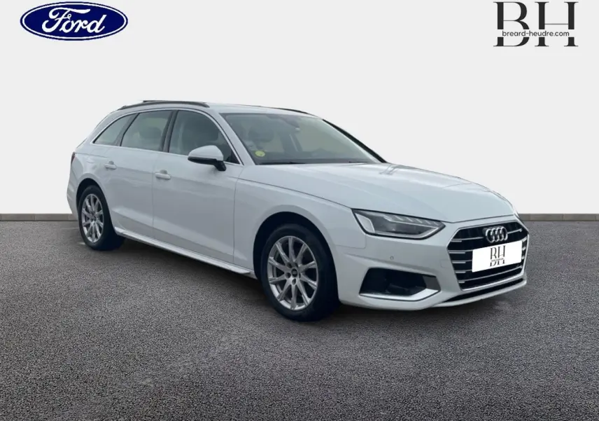 Audi A4 Avant blanc glacier métallisé vue 3/4 avant droit, avec jantes alu et barres de toit visibles.