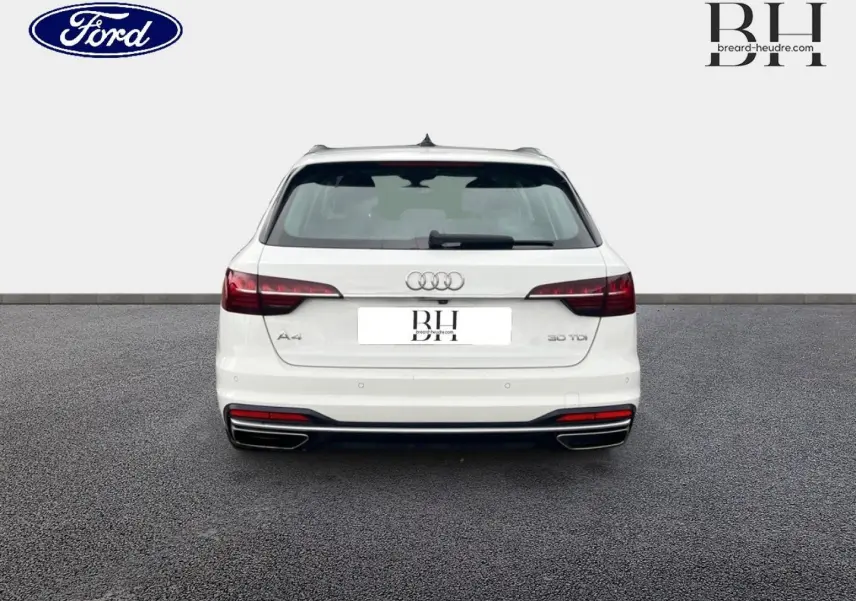 Vue arrière d'une Audi A4 Avant blanc glacier métallisé avec feux arrière LED et double sortie d'échappement chromée.