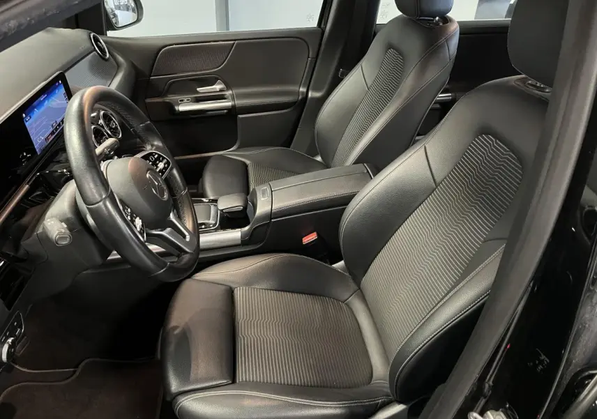 Intérieur noir de la Mercedes Classe B 180 d 2019, vue côté conducteur avec sièges en similicuir et tableau de bord digital.