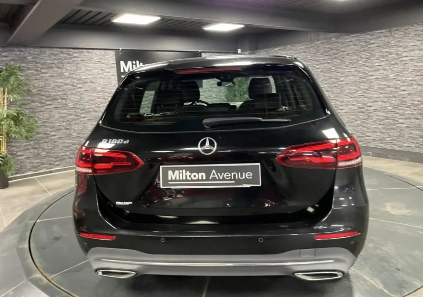 Vue arrière d'une Mercedes Classe B 180 d noire avec feux LED et double sortie d'échappement chromée.