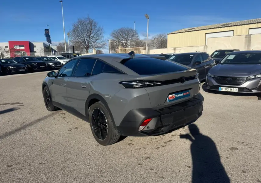 Peugeot 408 Hybrid gris vu en 3/4 arrière droit, avec jantes alliage noires et vitres teintées.