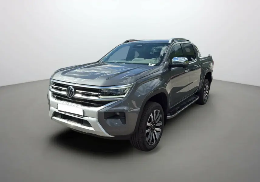 Volkswagen Amarok V6 240 BVA10 Aventura 4PL gris foncé, vue 3/4 avant avec jantes alu et barres de toit.