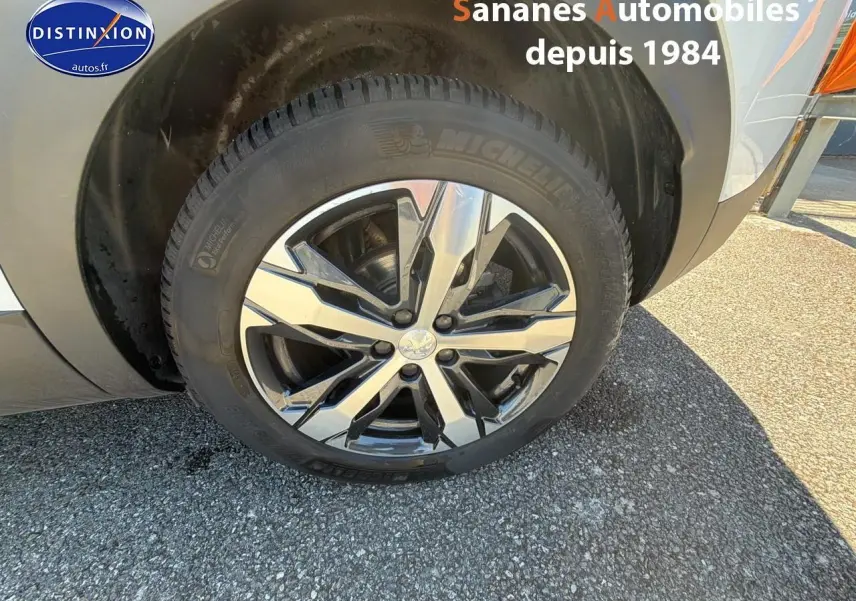 Gros plan sur la jante alliage bi-ton 18 pouces côté avant droit d'un Peugeot 3008 blanc nacré.