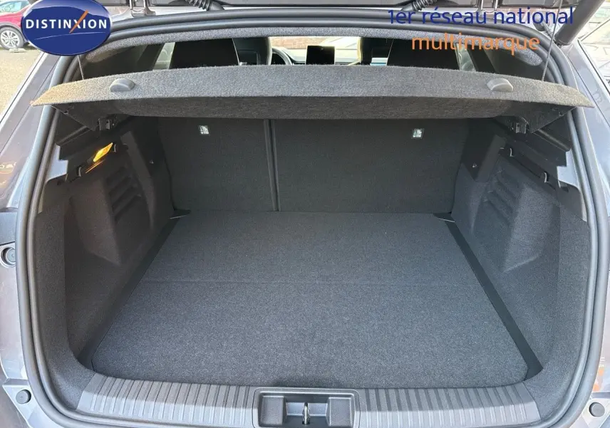 Coffre ouvert d'une Renault Symbioz gris Cassiope, vue arrière montrant l'espace de chargement et la tablette cache-bagages.