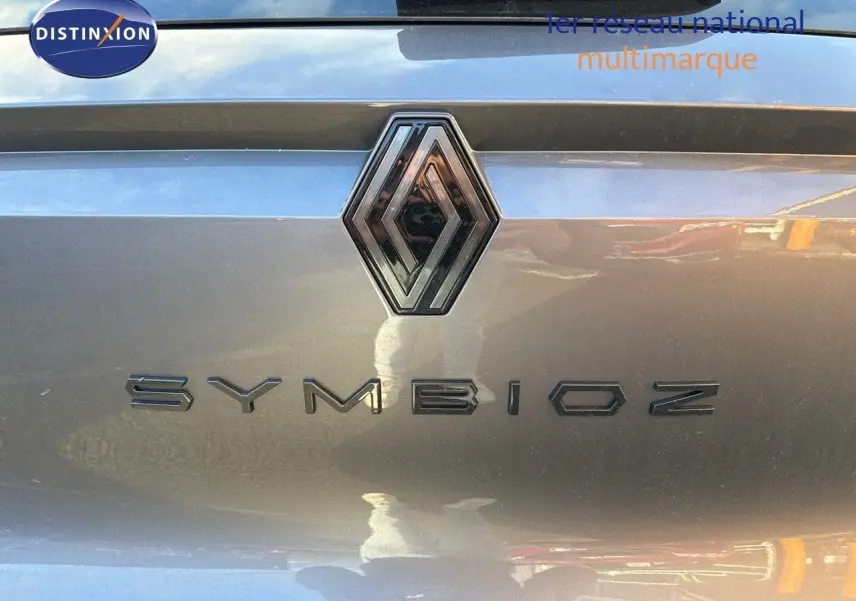 Gros plan sur le logo Renault et le nom Symbioz sur le hayon gris cassiope du SUV hybride 2024.