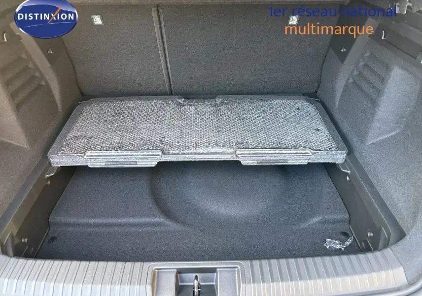 Coffre ouvert du Renault Symbioz gris Cassiope montrant le compartiment de rangement sous le plancher.