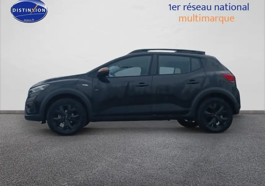 Profil côté gauche d'une Dacia Sandero Stepway noire 2025 avec barres de toit et jantes noires.