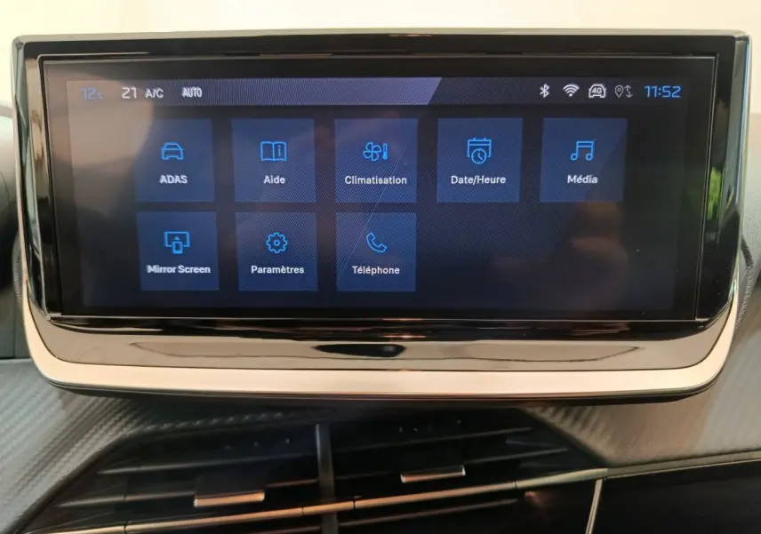 Écran tactile central de la Peugeot 208 PureTech 100 S&S Allure affichant les menus d'aide et climatisation.