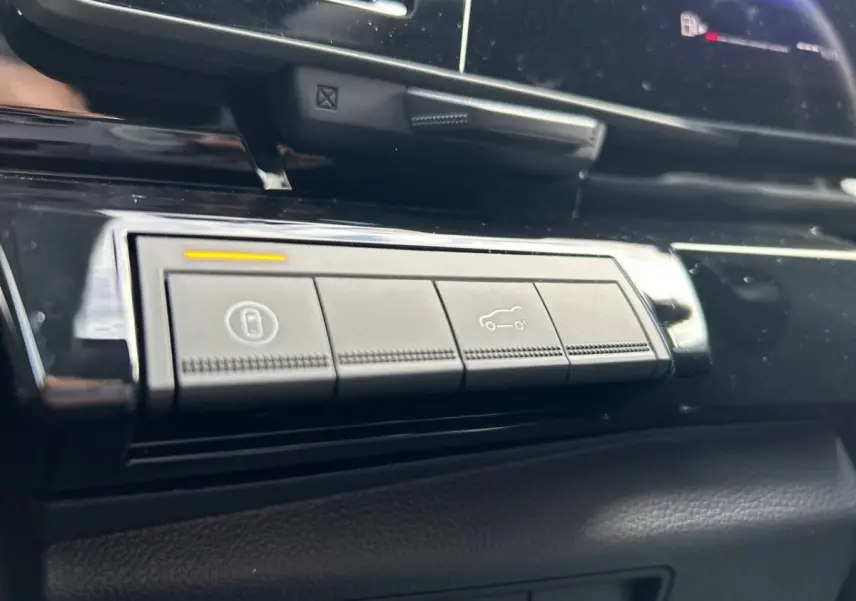 Gros plan sur les boutons de commande du tableau de bord noir du Renault Rafale esprit Alpine hybride 2025.