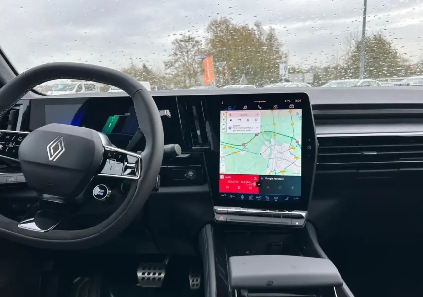 Intérieur noir de la Renault Rafale 2025 esprit Alpine, vue du tableau de bord avec grand écran tactile central affichant une carte.