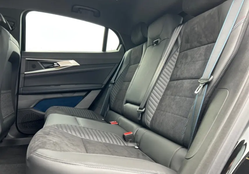 Vue intérieure côté droit des sièges arrière en cuir et alcantara noirs avec surpiqûres bleues du Renault Rafale 2025 esprit Alpine.