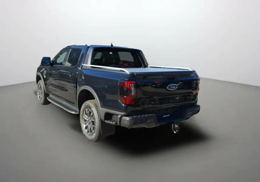 Ford Ranger 3.0 V6 Wildtrak Plus noir agate vu en 3/4 arrière droit avec attelage et barres de toit.