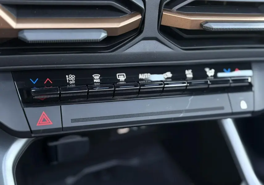 Gros plan sur la console centrale du Dacia Bigster 2026, avec commandes climatisation et boutons noirs mats.