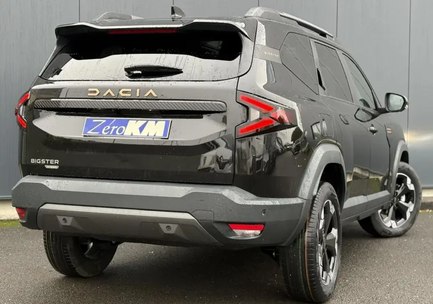 Vue 3/4 arrière droite du Dacia Bigster noir nacré 2026 avec hayon électrique et jantes alliage 18 pouces.