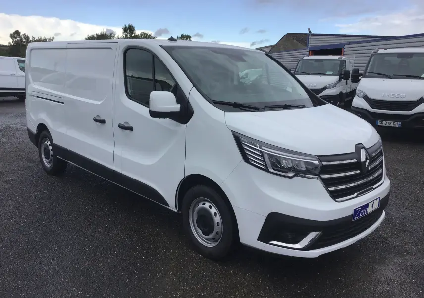 Renault Trafic Fourgon blanc en vue 3/4 avant droit, avec calandre noire et phares LED distinctifs.