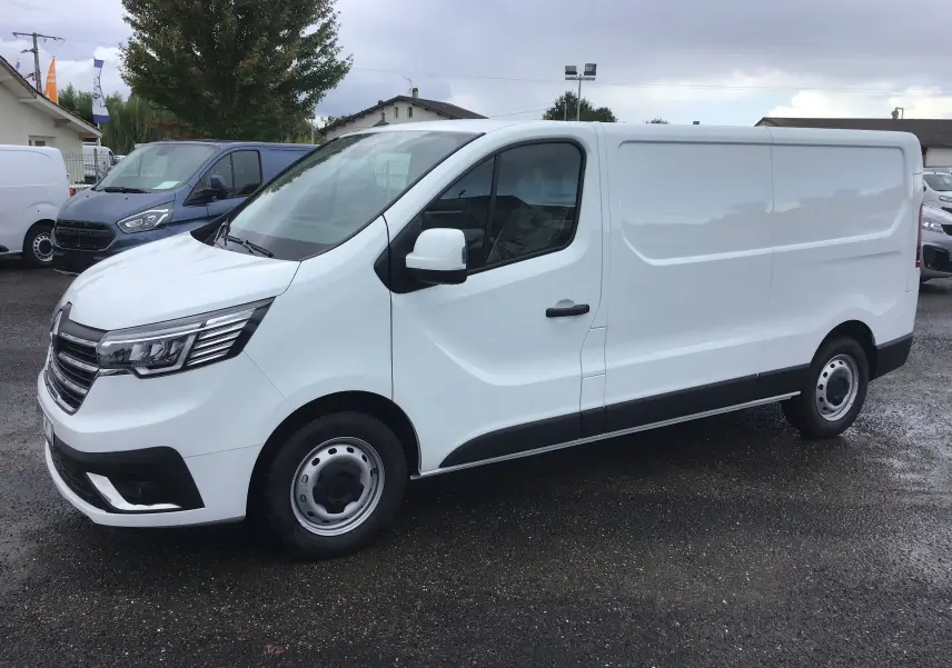 Renault Trafic Fourgon blanc vu de profil côté gauche, avec calandre noire et jantes acier simples.