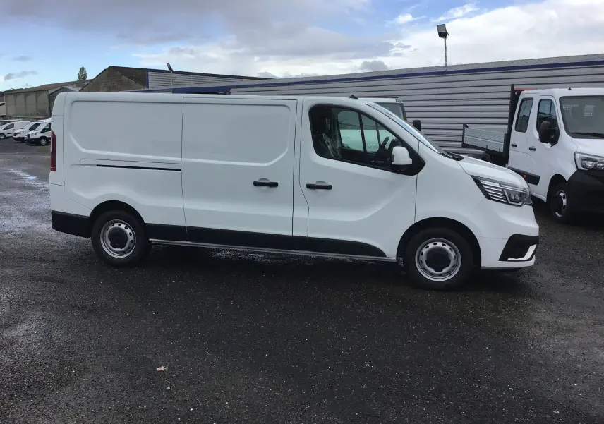 Renault Trafic Fourgon blanc vu de profil côté droit, avec portes coulissantes et jantes acier simples.