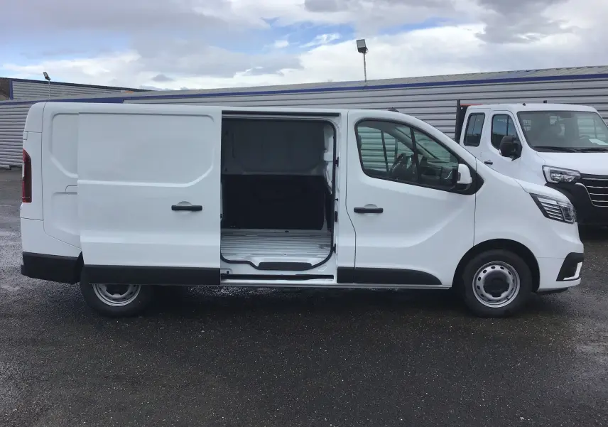 Renault Trafic Fourgon blanc vu de profil côté droit avec porte coulissante ouverte montrant l'espace de chargement.