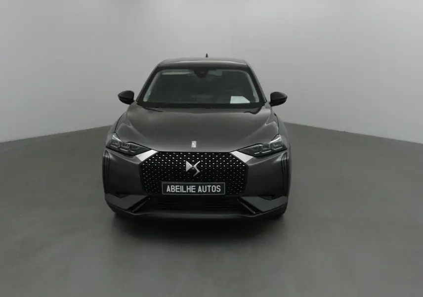 Vue frontale d'une DS3 Crossback gris platinium 2024 avec calandre distinctive et plaques Abeilhe Autos.