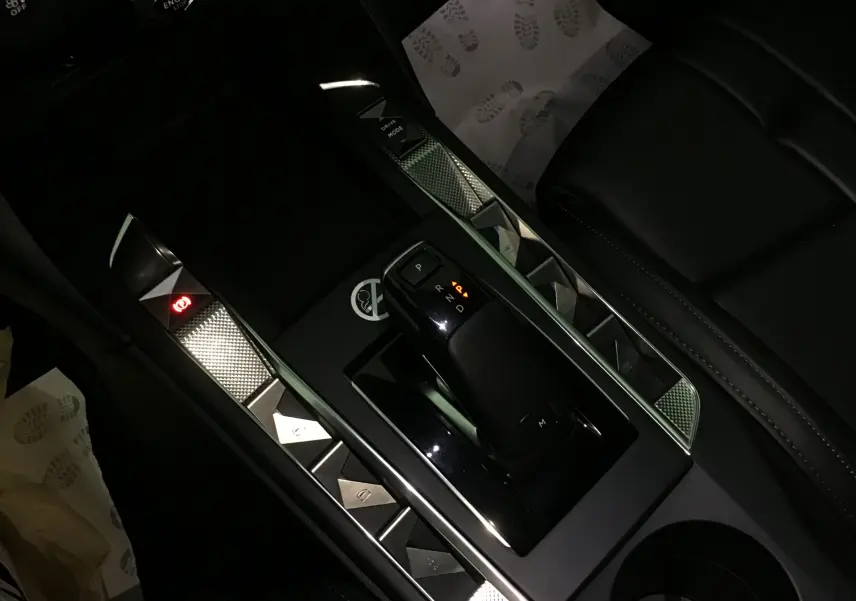 Vue rapprochée de la console centrale noire du DS3 Crossback 2024 avec levier de vitesse automatique et finitions métalliques.