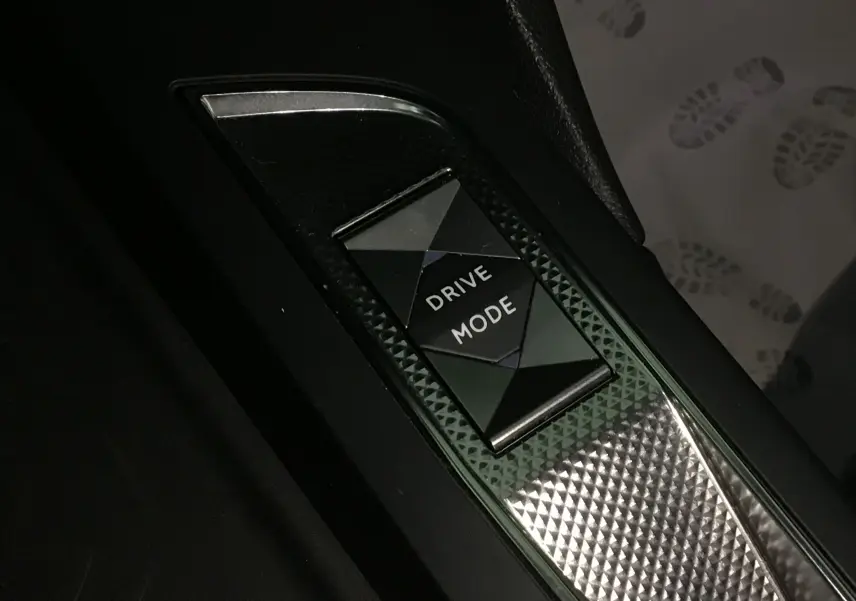 Gros plan sur le bouton Drive Mode au centre de la console intérieure du DS3 Crossback gris platinium 2024.