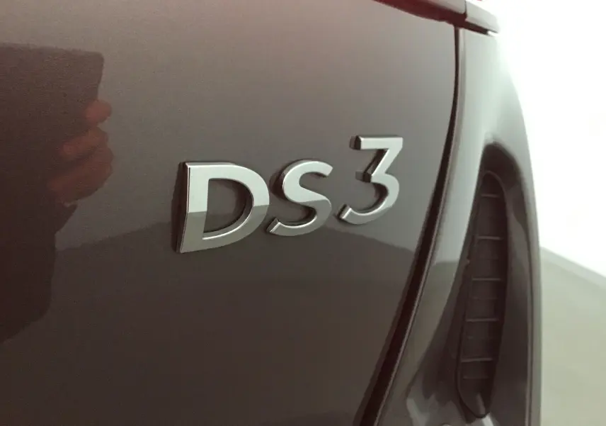 Gros plan sur l’inscription DS3 en relief sur la carrosserie gris platinium du DS3 Crossback 2024 côté arrière droit.