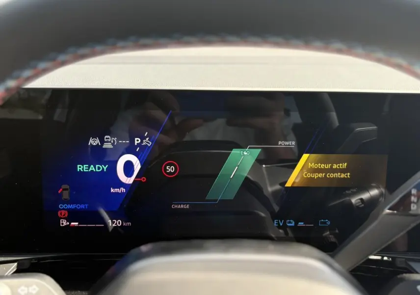 Affichage numérique du tableau de bord du Renault Austral E-Tech gris, montrant la vitesse à zéro et l'alerte moteur actif.