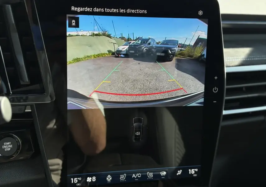 Écran tactile intérieur montrant la caméra de recul du Renault Austral gris Schiste avec lignes de guidage colorées.