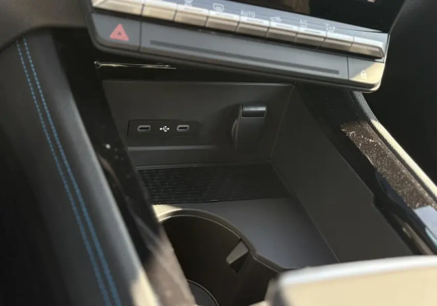 Gros plan sur la console centrale noire du Renault Austral E-Tech avec ports USB-C et rangement sous le tableau de bord.