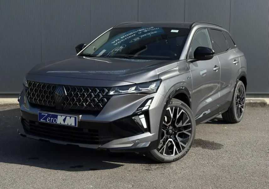 Renault Austral gris schiste en 3/4 avant droit, avec jantes alliage noires et calandre hexagonale distinctive.