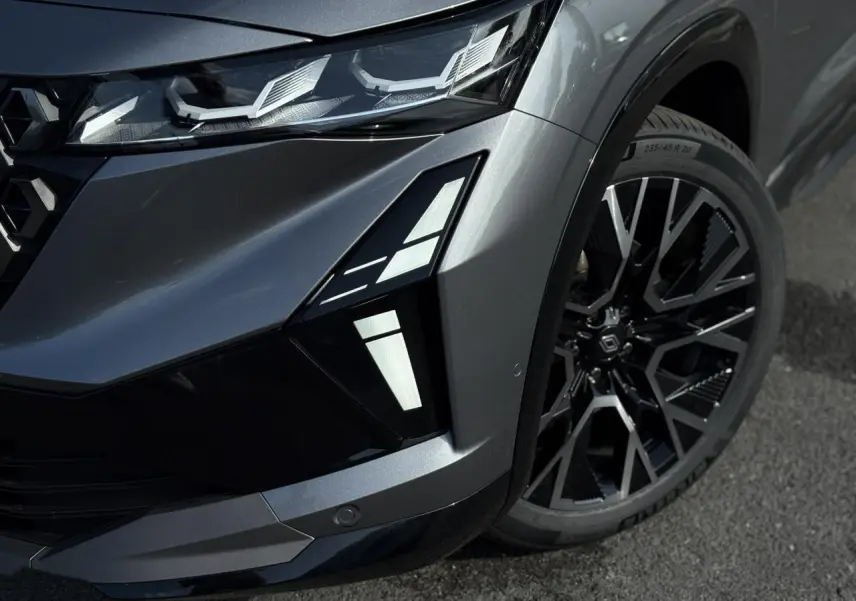 Gros plan sur l'avant droit gris schiste du Renault Austral E-Tech, mettant en valeur les feux LED et la jante alliage noire diamantée.