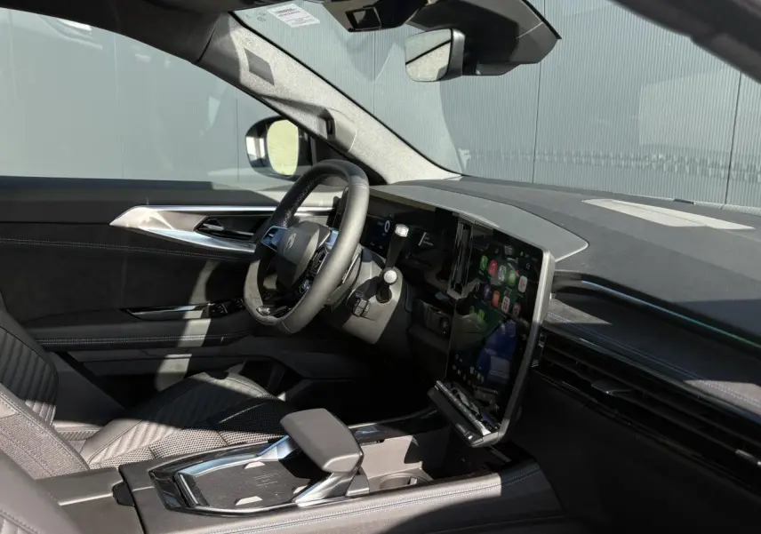 Intérieur du Renault Austral E-Tech gris, vue côté conducteur montrant volant Alcantara et écran tactile vertical.